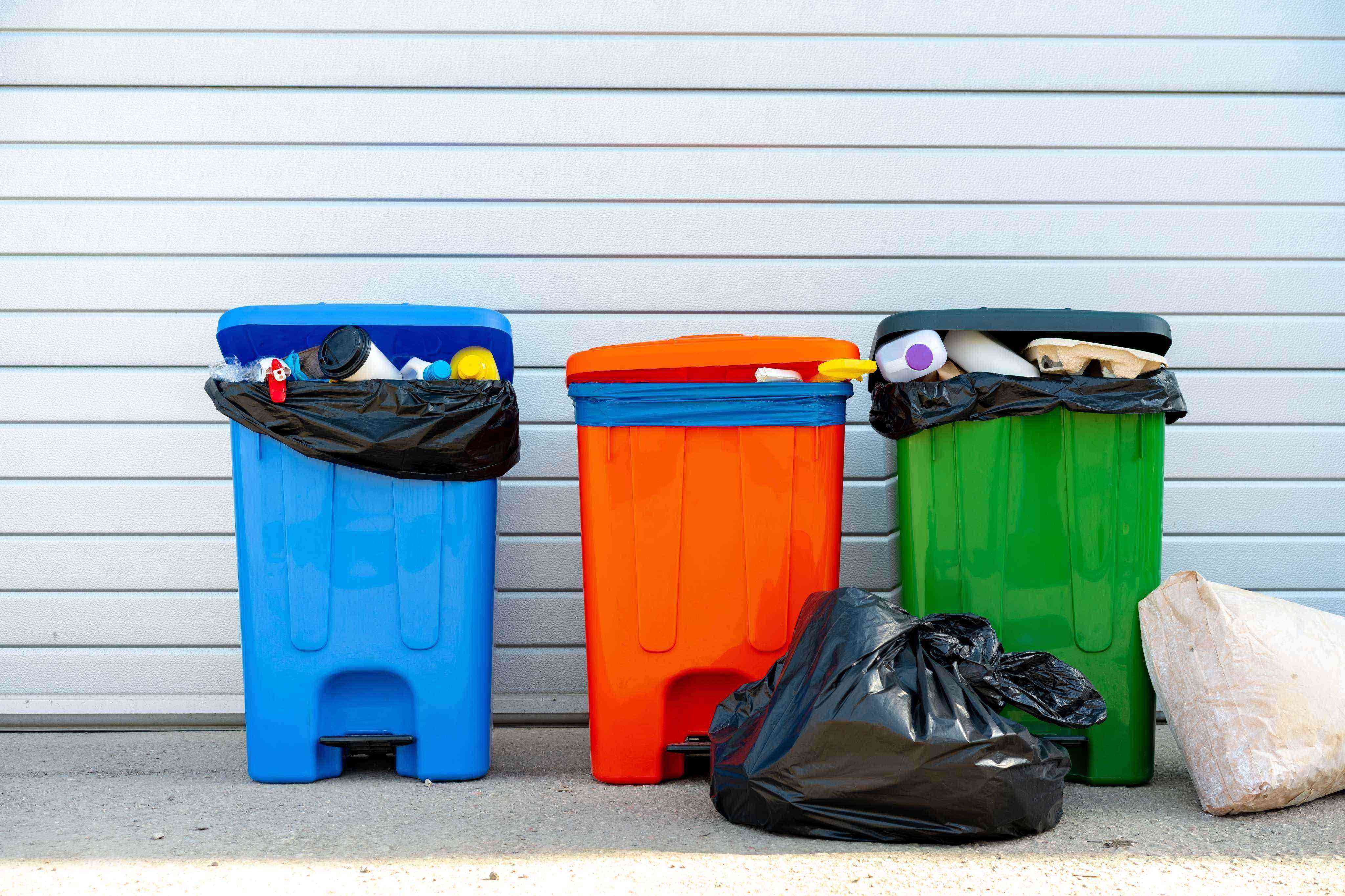 three-trash-containers-full-of-garbage-near-the-dumpster_zsh736DC2